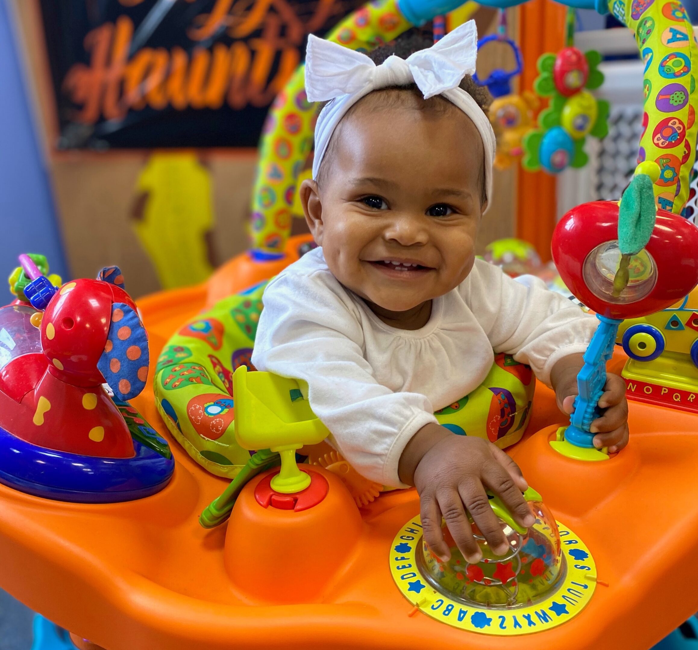 Baby smiling in colorful activity center