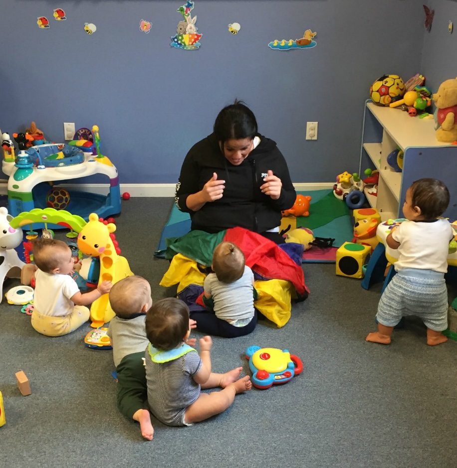 Caregiver interacting with toddlers in playroom